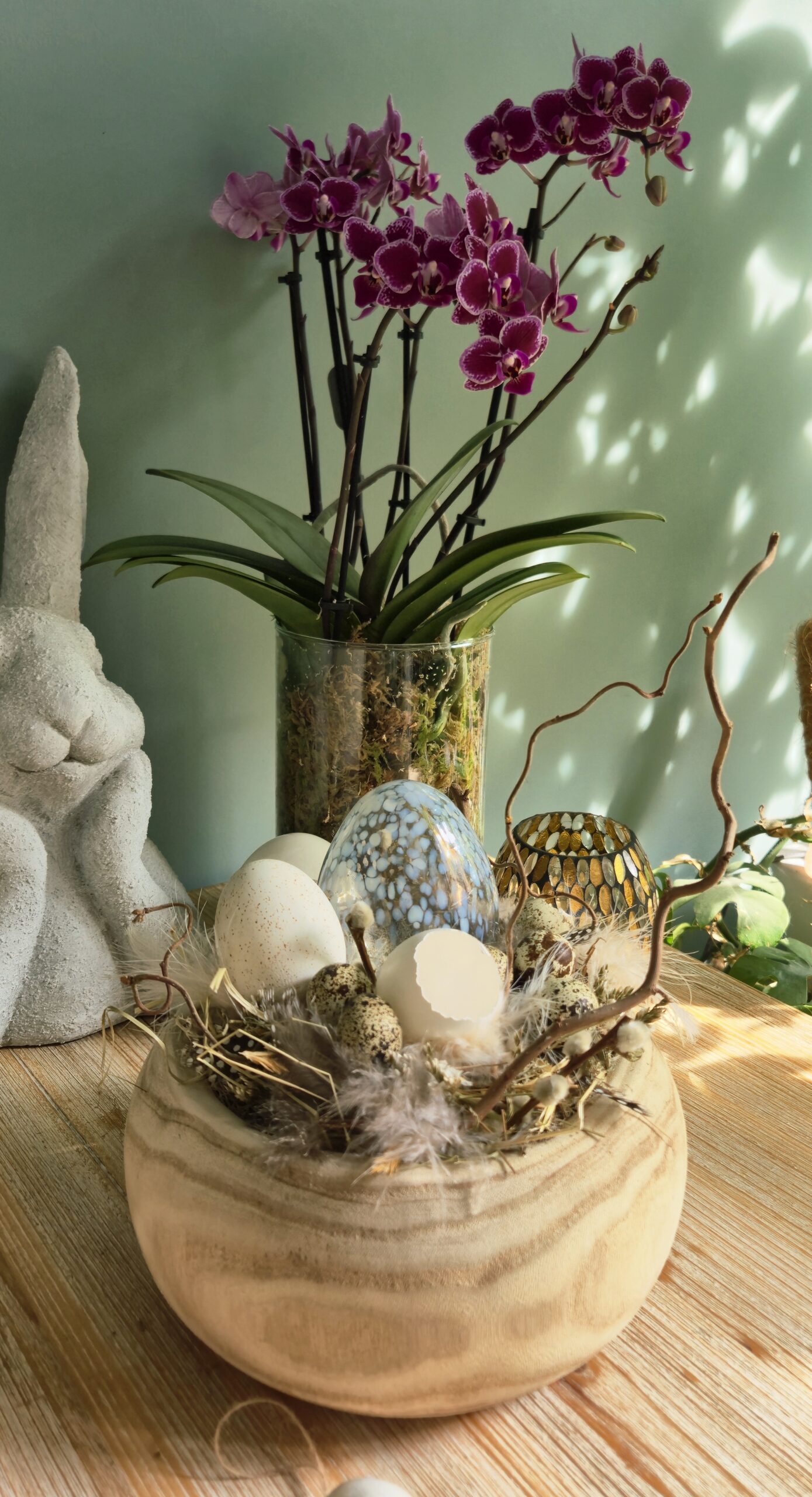 Montage de Pâques dans une coupe en bois de Paulownia, éléments naturels et oeuf en verre