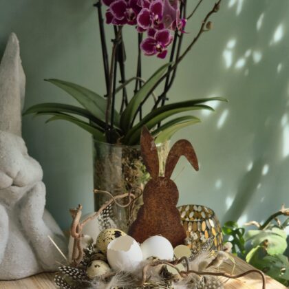 Montage de Pâques dans une coupe en bois de Paulownia, éléments naturels et lapin en acier rouillé